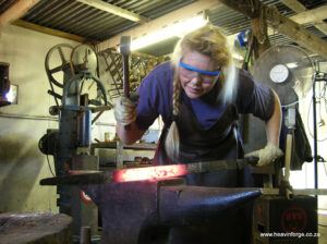 Photo of Heather forging out a damascus sword